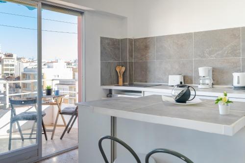 a kitchen with a counter and chairs and a balcony at Town center Apartment El Perello Valencia in Valencia