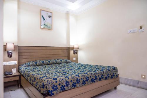 a bedroom with a bed with a blue comforter at Hotel Sagar in Guwahati