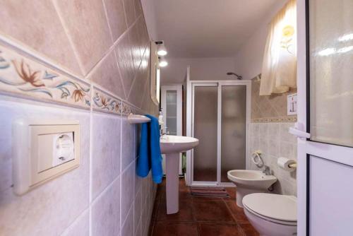 uma casa de banho com 2 lavatórios, um WC e um chuveiro em 3 bedrooms house at Los Caserones 50 m away from the beach with enclosed garden and wifi em Las Marciegas