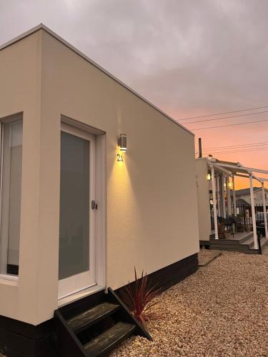 un edificio blanco con una puerta a un lado en Peninsula Beachside Accommodation en Capel Sound