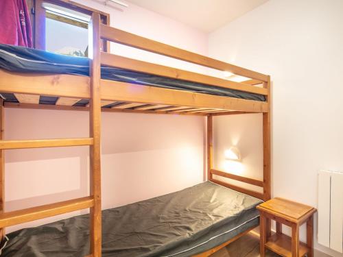 Cette chambre dispose de lits superposés avec 2 lits superposés et une table. dans l'établissement Les Ecureuils - A09 - Appart Chaleureux - 6 pers, à Saint-Sorlin-dʼArves