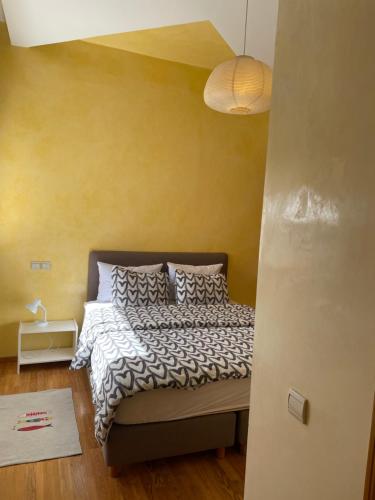a bedroom with a bed and a yellow wall at Perle de Nouaceur 1 in Nouaseur