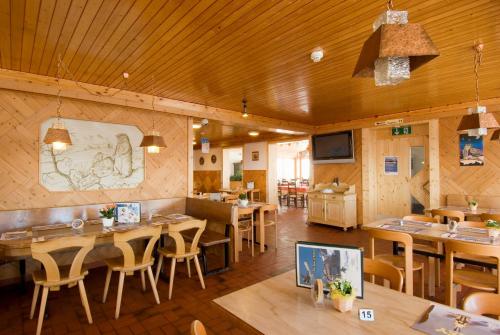 a restaurant with wooden walls and wooden tables and chairs at Berggasthaus Zanuz in Bad Ragaz