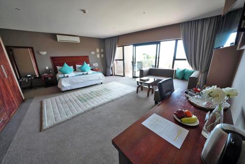 a hotel room with a bed and a desk and a table sidx sidx at Over The Moon Guesthouse in Johannesburg