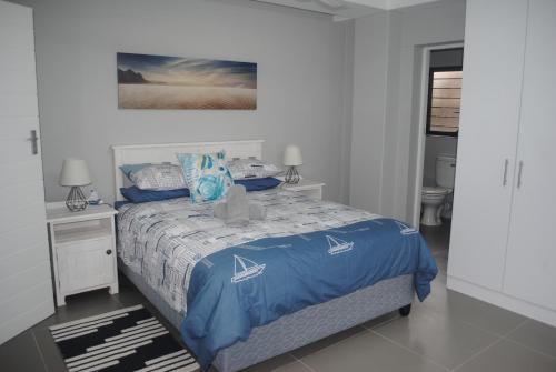 Un dormitorio con una cama con un edredón azul. en Barefoot Bungalo, en Amanzimtoti
