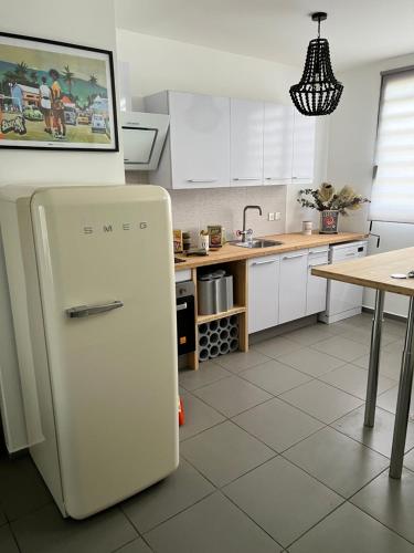 a white refrigerator in a kitchen with a table at buena vista in LʼÉperon