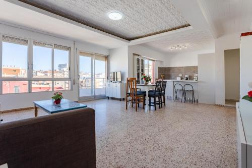 cocina y sala de estar con mesa y sillas en Town center Apartment El Perello Valencia, en Valencia