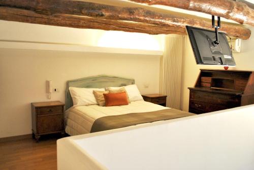 1 dormitorio con 1 cama y TV en Casa Cicala, en Melito di Napoli