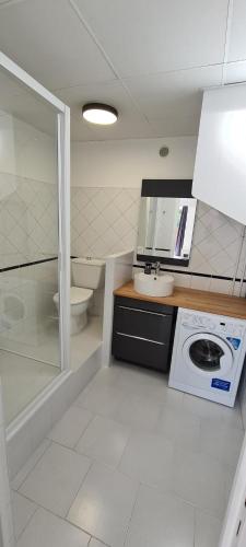 a bathroom with a washing machine and a toilet at Ô Phil du Vent' in Ventabren