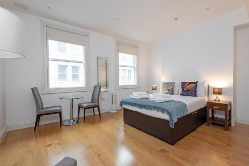 ロンドンにあるStayo Oxford Streetのベッドルーム1室(ベッド1台、テーブル、椅子2脚付)