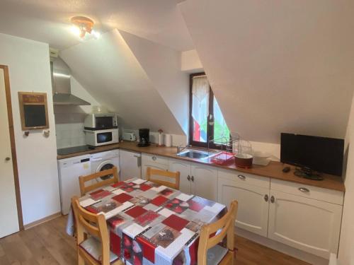une cuisine avec une table et une cuisine avec une table et des chaises dans l'établissement Appartement 3 pièces avec balcon à Villard-de-Lans - FR-1-515-34, à Villard-de-Lans