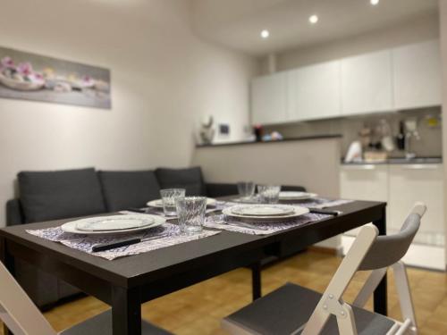 - une table avec des assiettes et des verres dans la cuisine dans l'établissement Appartamento Bandiera Blu, à Sirolo