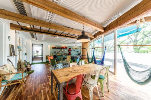 a dining room with a wooden table and chairs at 365BASE outdoor hostel in Hamamatsu