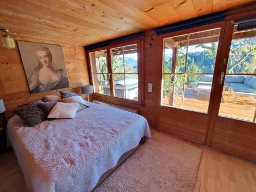 ein Schlafzimmer mit einem Bett in einer Holzhütte in der Unterkunft Gstaad Paradise View Chalet with Jacuzzi in Rougemont