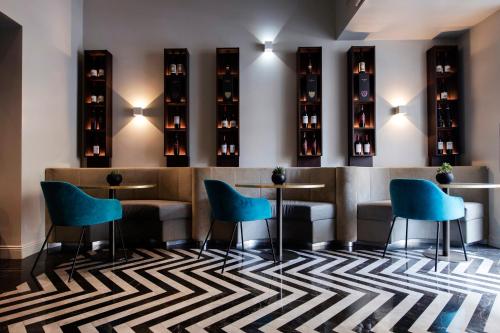 a bar with blue chairs and wine bottles at Hotel 87 eighty-seven - Maison d'Art Collection in Rome