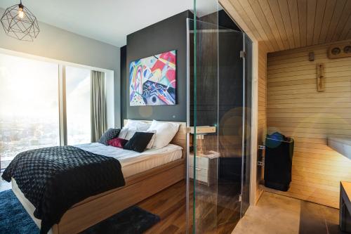 a bedroom with a bed and a glass wall at 30th+ Floor Apartments in Sky Tower in Wrocław