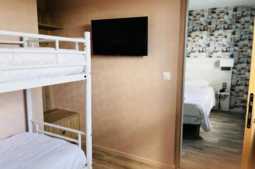a room with two bunk beds and a flat screen tv at The Originals Access, Hôtel les Iris, Berck-sur-Mer in Berck-sur-Mer
