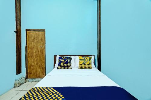 Habitación azul con cama con almohadas en SPOT ON 91916 Joglo Doyong Homestay Syariah en Yogyakarta