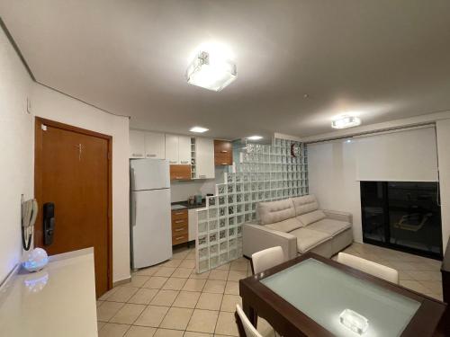 een keuken en een woonkamer met een bank en een koelkast bij AP1310 - Região dos hospitais, piscina e garagem in Sao Paulo