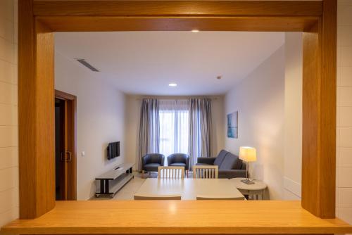 a living room with a table and some chairs at Primera Planta Punta Umbria 2 dormitorios junto al mar (1) in Punta Umbría