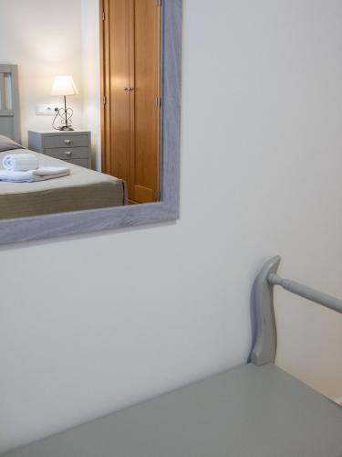 a mirror on the wall of a room with a bed at Primera Planta Punta Umbria 2 dormitorios junto al mar (1) in Punta Umbría