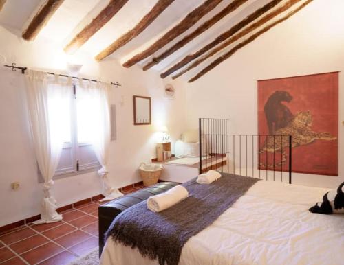 a bedroom with a large bed and a window at Casa rural con jacuzzi y chimenea en paraje único - La Casa del Pino in Blanca