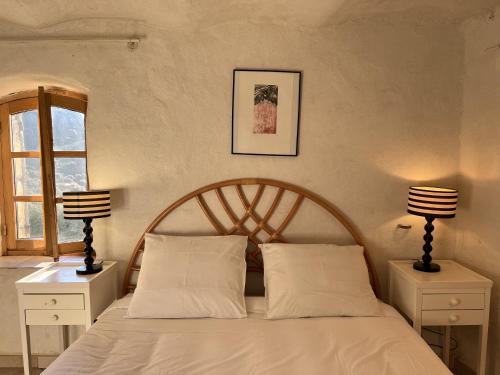 a bedroom with a bed with white sheets and two lamps at Casa Musicale in Pigna