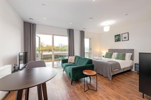 ein Hotelzimmer mit einem Bett, einem Sofa und einem Tisch in der Unterkunft Stayo Apartments Barking Wharf in London