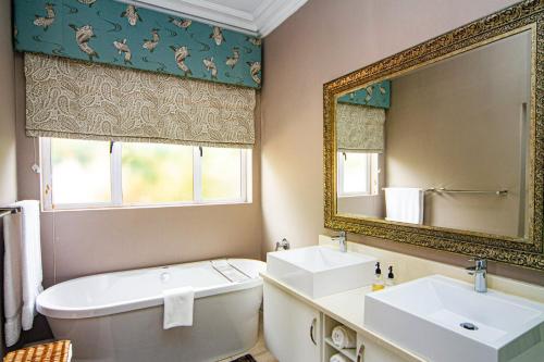 a bathroom with a tub and a sink and a mirror at Pete's Place in Durban