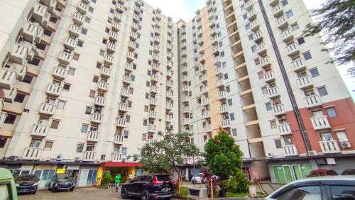 a large building with cars parked in front of it at Lily Room at Apartment Cibubur Village in Cibubur