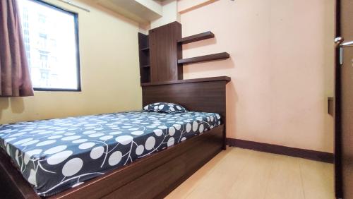 a small bedroom with a bed and a staircase at Lily Room at Apartment Cibubur Village in Cibubur