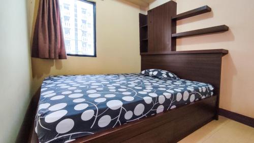 a bedroom with a bed with a black and white bedspread at Lily Room at Apartment Cibubur Village in Cibubur