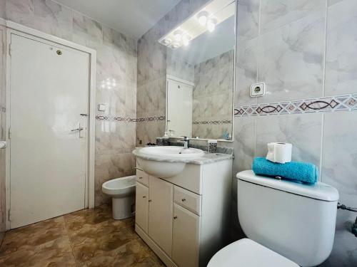 ein Badezimmer mit einem WC, einem Waschbecken und einem Spiegel in der Unterkunft Apartamento Alaska acogedor y a 100metros de la playa in Salou