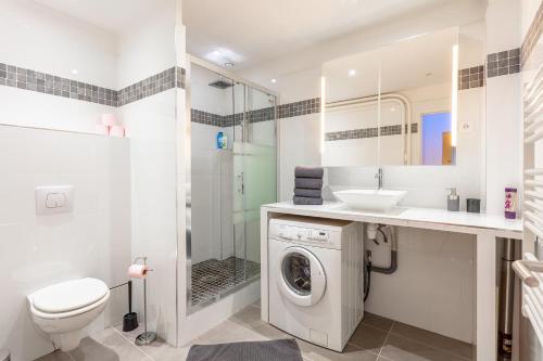 ein Badezimmer mit einer Waschmaschine und einem Waschbecken in der Unterkunft Victor Hugo Flat in Paris