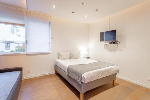 ein Schlafzimmer mit einem Bett und einem TV an der Wand in der Unterkunft Victor Hugo Flat in Paris