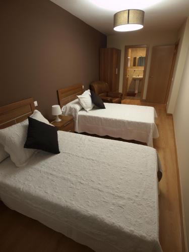 a hotel room with two beds and a room with at Casa Rural El Cipres in Santo Domingo de Silos