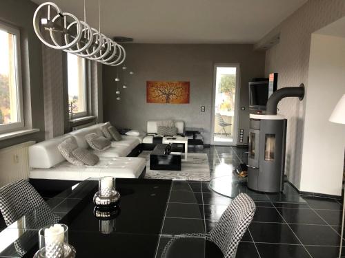 a living room with a white couch and a fireplace at Haus Brockenblick in Wernigerode