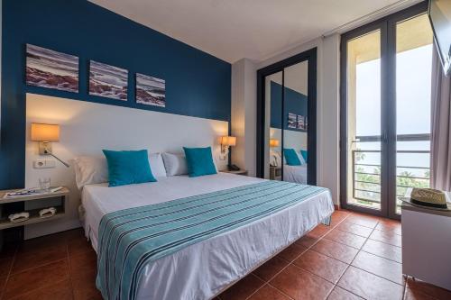 Un dormitorio con una cama grande con paredes azules. en Estival Islantilla, en Islantilla