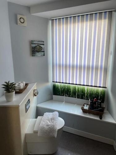 een badkamer met een toilet en een groot raam bij The Thisle in Bristol
