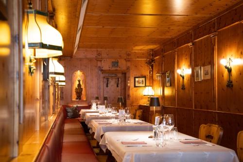 a row of tables in a restaurant with white table linens at Gasthof OHR in Eisenstadt