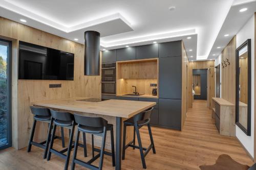 a kitchen with a wooden table and chairs at SCANDIC Apartments Boží Dar in Boží Dar