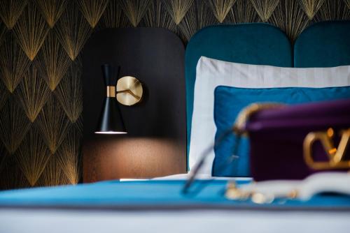 a bedroom with a blue bed with a pillow and a lamp at Hotel 87 eighty-seven - Maison d'Art Collection in Rome