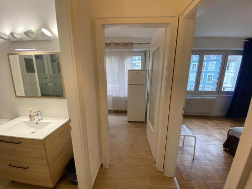 a bathroom with a sink and a kitchen with windows at Appartement Gare Strasbourg Parking in Strasbourg