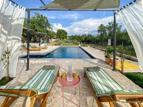 a patio with two chairs and a table and a pool at Villa Vinka in Kozica
