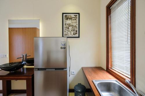 a kitchen with a stainless steel refrigerator and a sink at Dinar Hills Ungasan in Nusa Dua