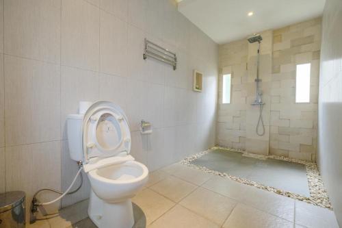 a bathroom with a toilet with the lid up at Dinar Hills Ungasan in Nusa Dua