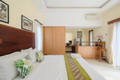 a bedroom with a large bed and a kitchen at Dinar Hills Ungasan in Nusa Dua