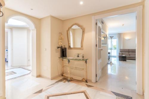 a living room with a table and a mirror at VIP Dominion Beach Estepona in Estepona