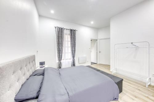 a bedroom with a large bed in a white room at J Mo Home - Tonnerre - O' Verre in Tonnerre