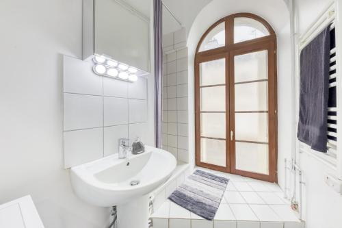 a white bathroom with a sink and a window at J Mo Home - Tonnerre - O' Verre in Tonnerre